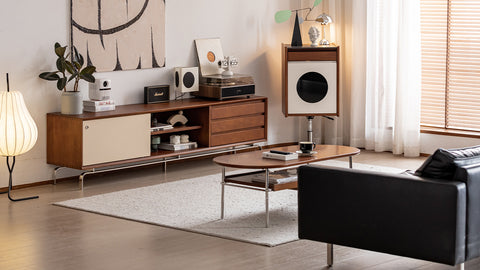 Modern living room with wooden furniture, black sofa, and decorative items.
