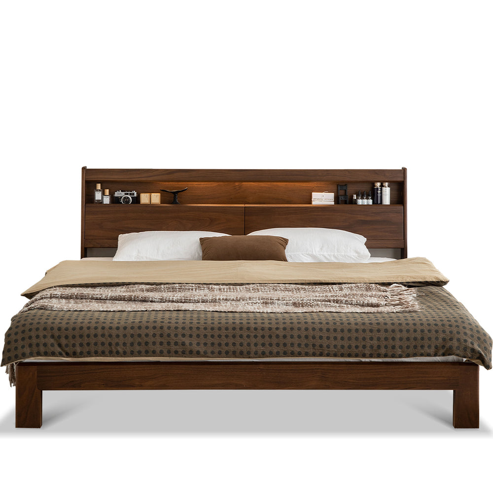 Wooden bed with bedding and headboard shelves on a white background