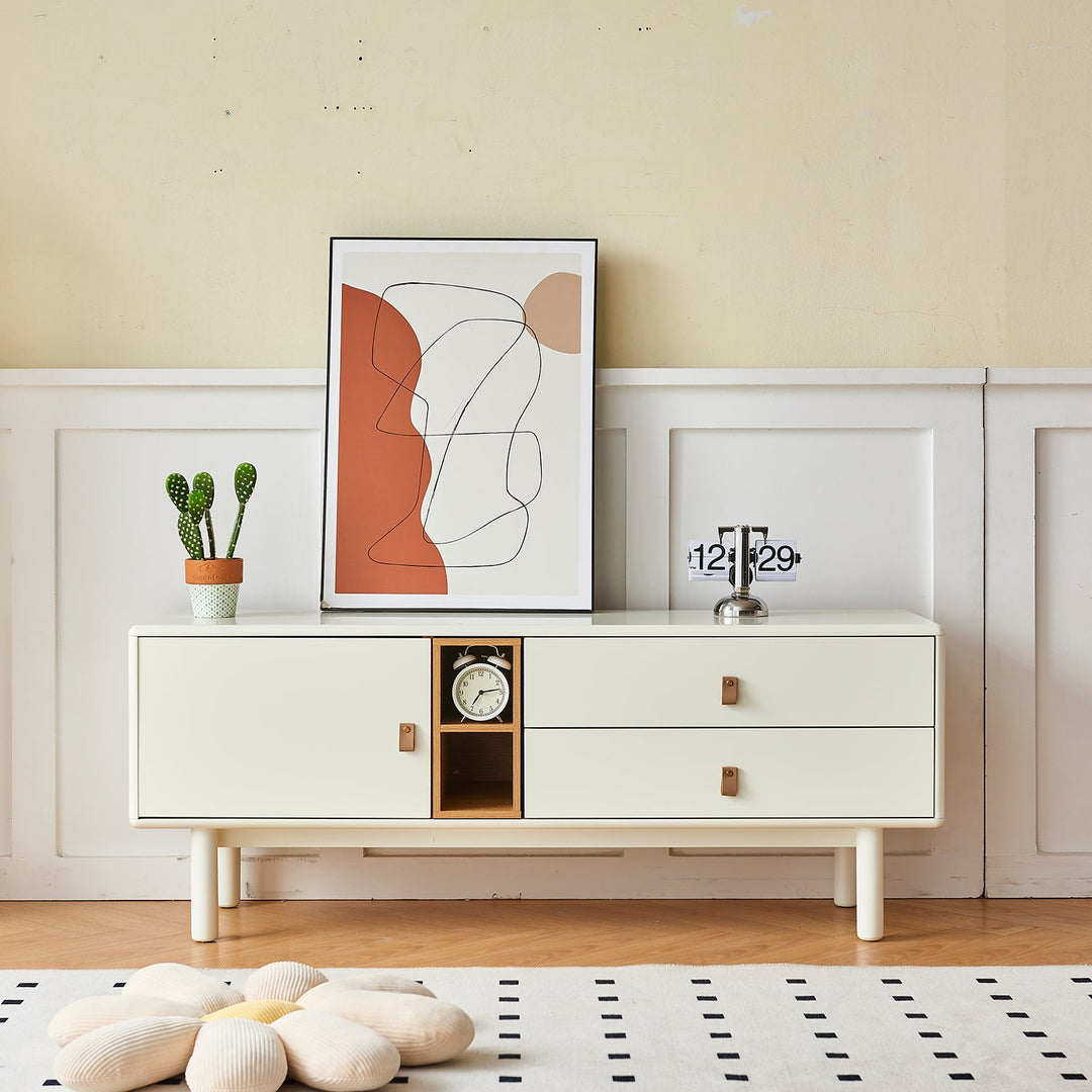 Modern TV console in white finish with sleek drawers and an open shelf, complemented by leather handles, ideal for minimalist and contemporary interiors.